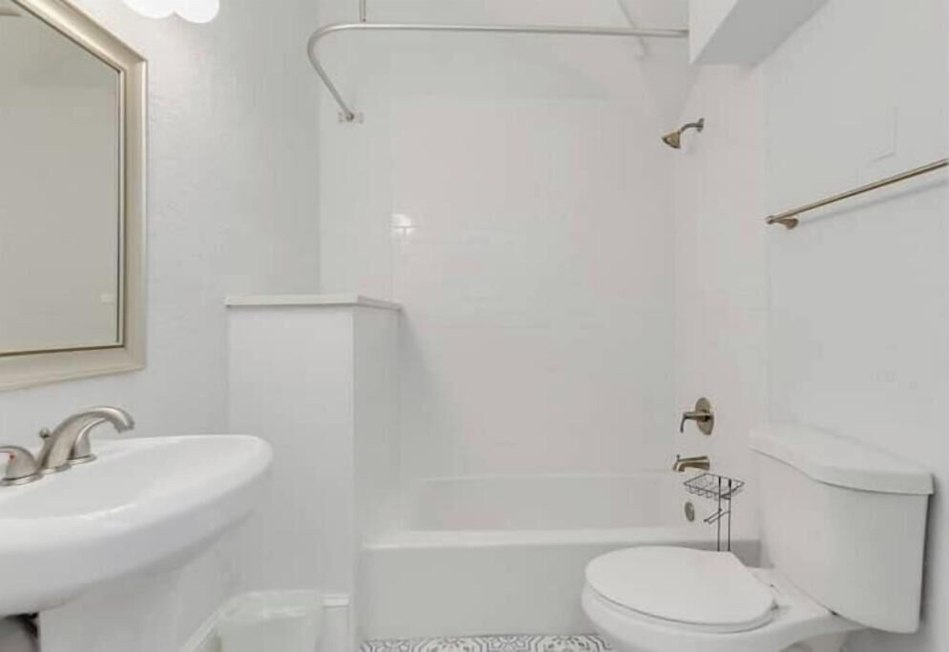 Een badkamer met een wastafel, toilet en douche.