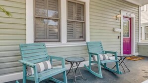 A porch with two rocking chairs and a small table, a door with the number 1142, and a window with shutters. - 1142- Bamboo Oasis, Great Entertaining, 1 Mile to Arenas, Pet & Family Friendly (Jacksonville)