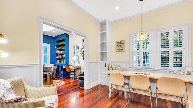A dining area with a wooden table and chairs, a bookshelf, and a window with blinds. - 1142- Bamboo Oasis, Great Entertaining, 1 Mile to Arenas, Pet & Family Friendly (Jacksonville)
