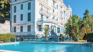 A multi-story hotel with a swimming pool in front. - Belvedere Hambury Apartment by Wonderful Italy (Bordighera)