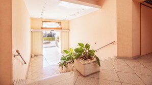 A modern hotel lobby with a spacious entrance, a handrail, and potted plants. - Belvedere Hambury Apartment by Wonderful Italy (Bordighera)