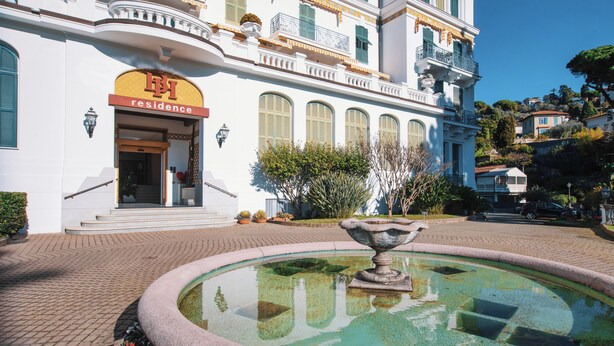 A building with a sign reading "residence" and a fountain in the courtyard. - Belvedere Hambury Apartment by Wonderful Italy (Bordighera)