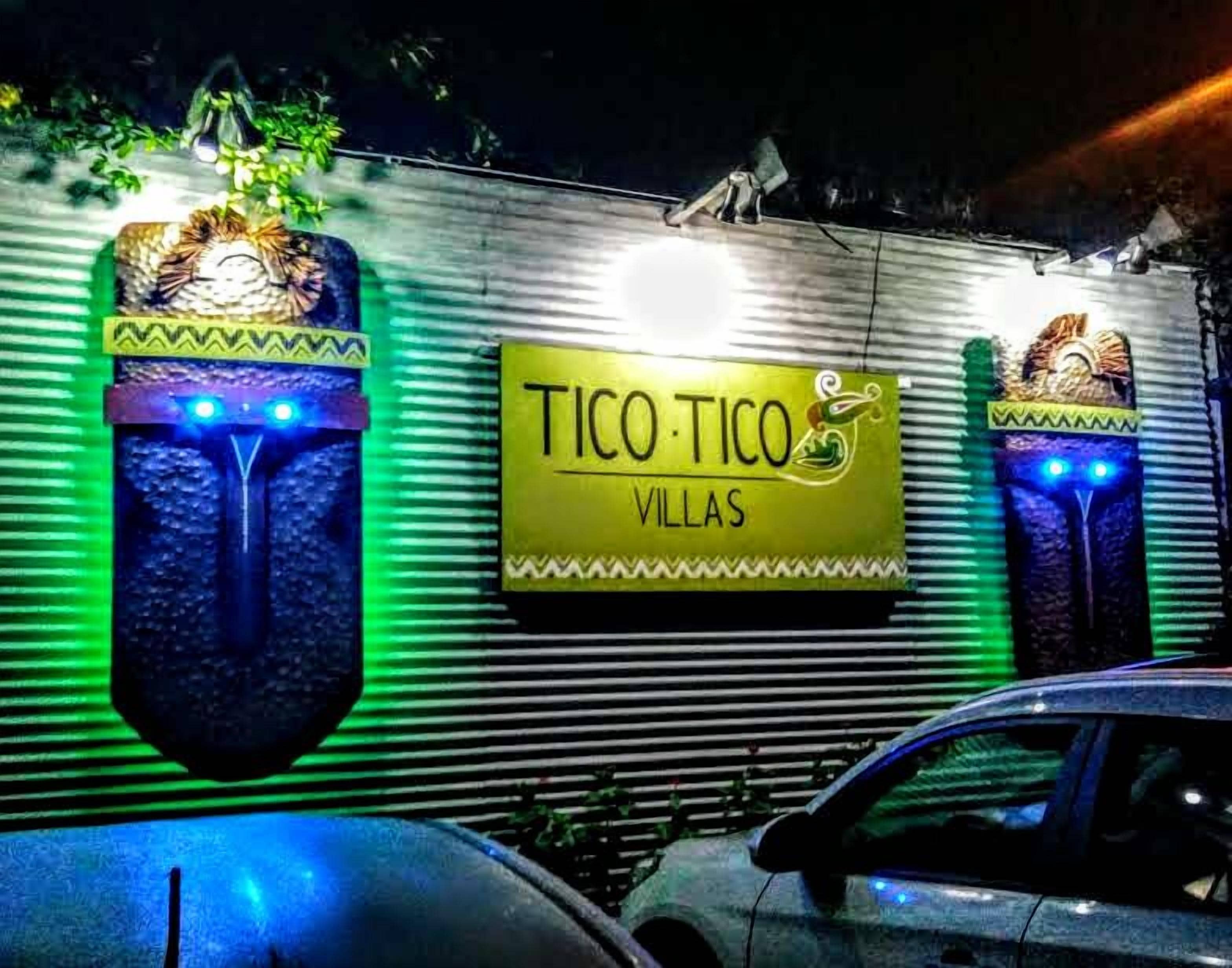 Un edificio con un letrero que dice "TICO TICO VILLAS" y elementos decorativos que evocan máscaras tradicionales.