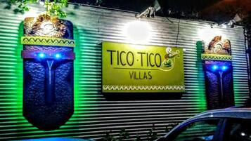 Un edificio con un letrero que dice "TICO TICO VILLAS" y elementos decorativos que evocan máscaras tradicionales.