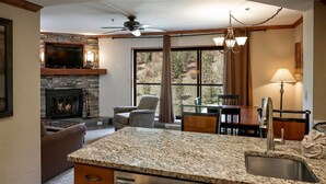 A kitchen with granite countertops, a built-in stove, and a large window overlooking a forest. - Gorgeous Views. 9 Hot Tubs. Ski-in/Ski-out Studio! (Breckenridge)