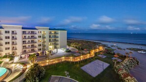 Un hôtel à plusieurs étages, doté d'une piscine et offrant une vue sur la plage.