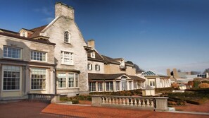 A large, historic building with multiple windows and a brick pathway. - Queen Suite with In-Suite Conference Space Near the University of Rochester (Rochester)