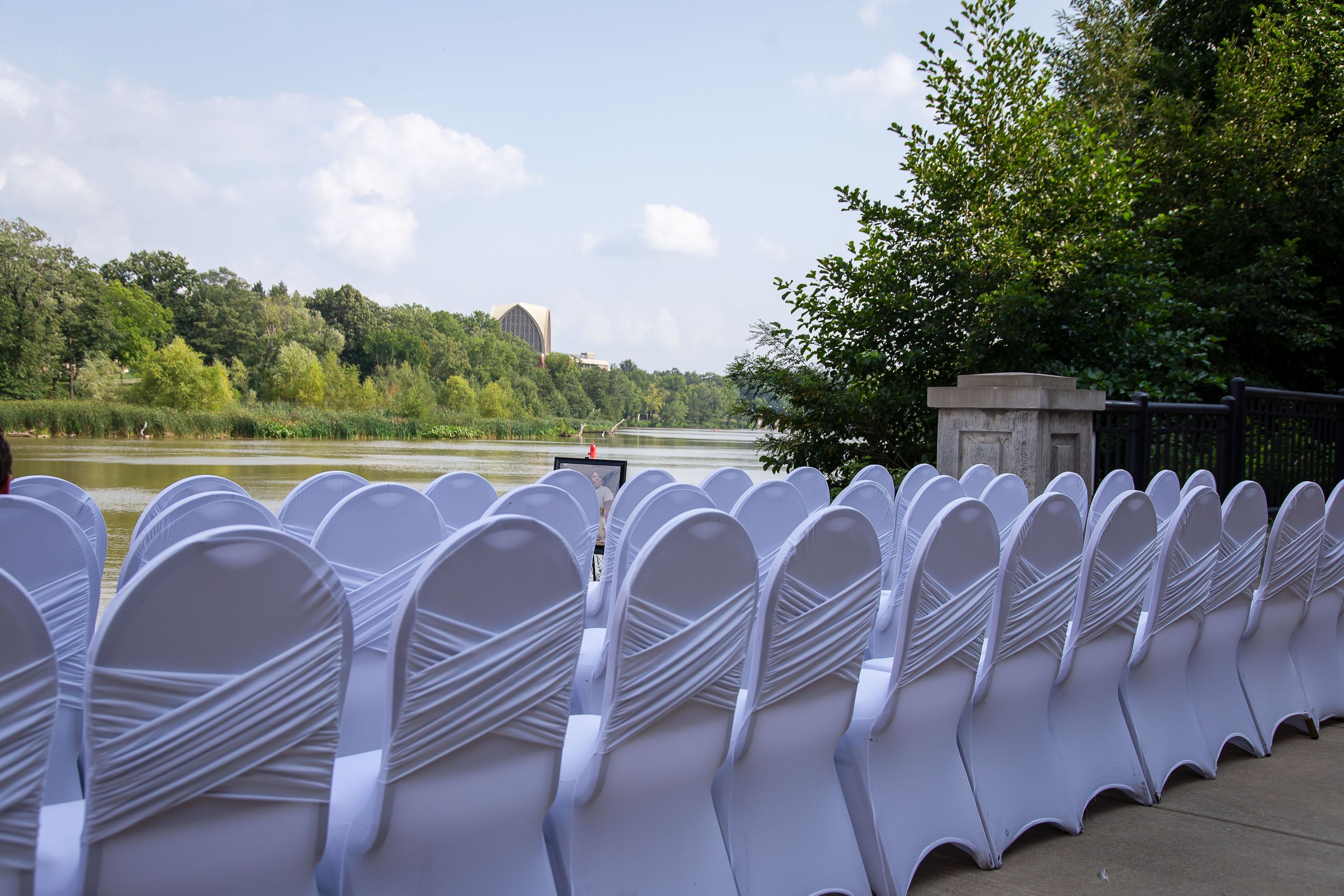 Row of chairs facing the Genesee River and surrounding greenery.