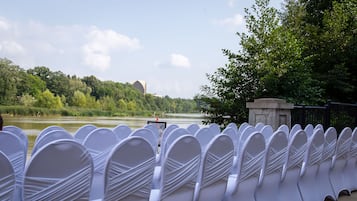 Row of chairs facing the Genesee River and surrounding greenery.