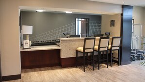 Un espace cuisine moderne doté d’un bar, de sièges et d’un escalier menant à un niveau supérieur.