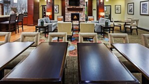 Un hall d’hôtel doté d’une cheminée, d’un espace salon et d’un bar.
