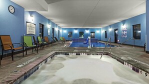 Une piscine dont le bord est revêtu de carrelage, avec des chaises longues et une horloge au mur.