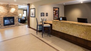 A reception area with a stone fireplace, two chairs, a counter, and a bookshelf.