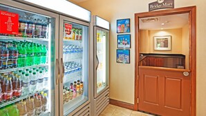 A hallway with a BridgeMart sign, a refrigerator stocked with beverages, and a door to a room. - King Suite. Free Breakfast. Pool & Gym. Close to the University of Tennessee Arboretum! (Oak Ridge)