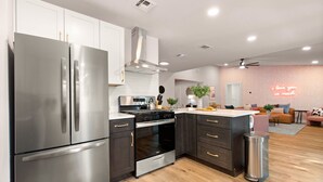 A modern kitchen with stainless steel appliances, dark cabinetry, and a central island. - Pool, Pickleball, Resort Backyard, 16min to Downtown - Modern Cowgirl (Austin)