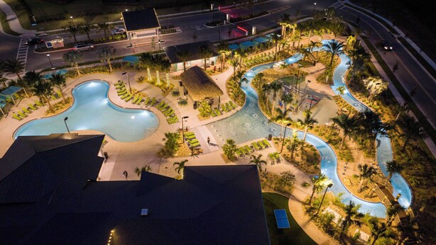 An aerial view of a resort with multiple pools, palm trees, and a well-lit walkway. - Private 4BR Check In and Chill Out (2417ST) (Kissimmee)