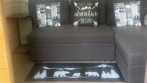 A sectional sofa with three cushions, each featuring wildlife and nature-themed designs. Above the sofa, there are three framed pictures depicting mountain landscapes. - Woods I GO 2 Lose my Mind Roscoe (Roscoe)