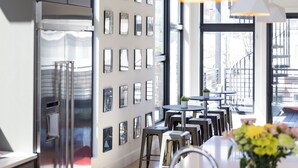 Una cocina moderna con electrodomésticos de acero inoxidable, iluminación colgante y una pared decorada con cuadros.