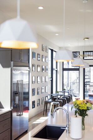 Enjoy cooking in this well-lit kitchen with a large island and stainless steel refrigerator.