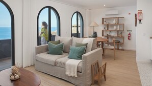 Ein modernes Wohnzimmer mit einer Couch, einem Holztisch und einem Essbereich mit Tisch und Stühlen.