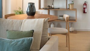 Ein gemütliches Wohnzimmer mit einer Couch, einem Holzesstisch und einem Bücherregal.