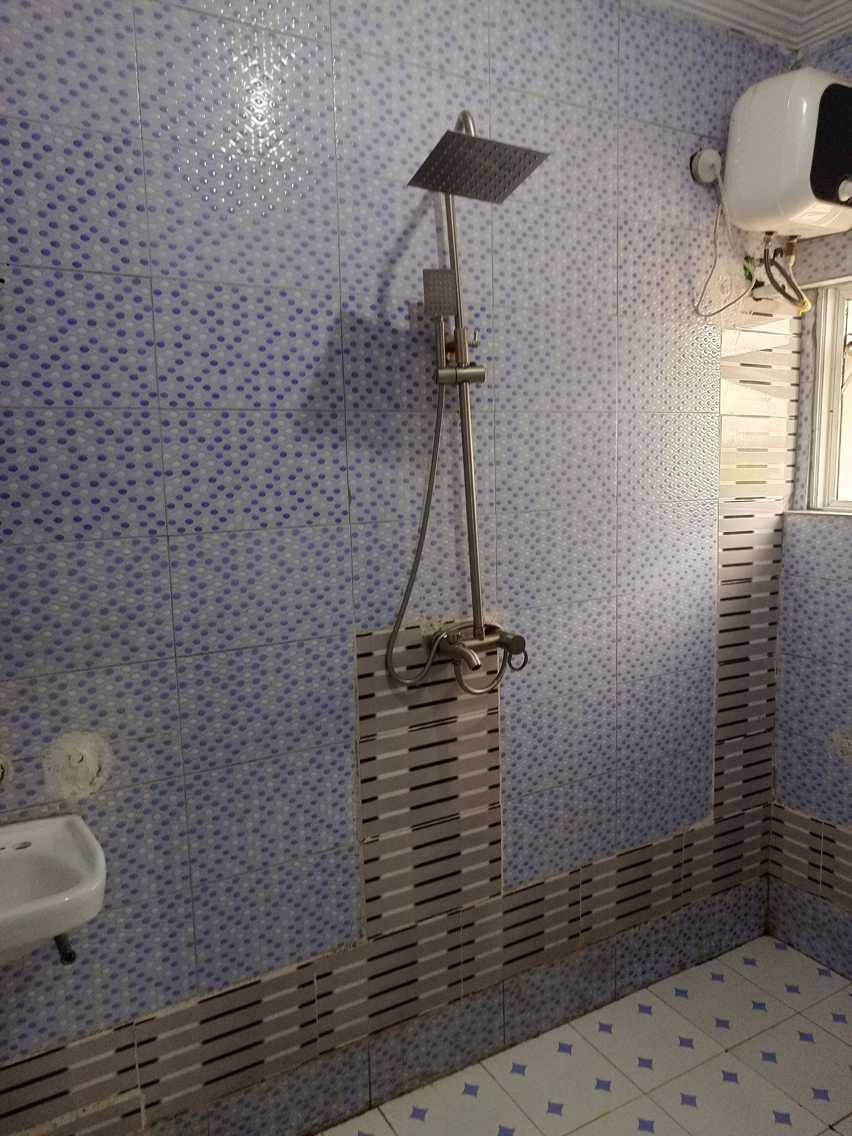 Une salle de bain équipée d’une douche, de toilettes et d’un sèche-mains.