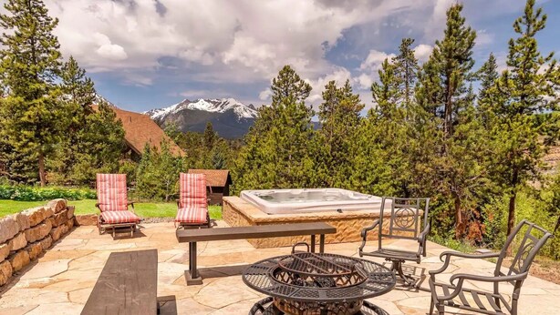 A patio with outdoor furniture, a hot tub, and a stone fireplace. - Pet Friendly Outdoor Enthusiast's Retreat. Walk to Lake Dillon! (Dillon)