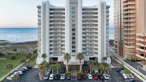 A multi-story hotel with a central entrance and balconies on each floor. - Stylish Beachfront Retreat ~ Gulf Views ~ Pools! (Orange Beach)