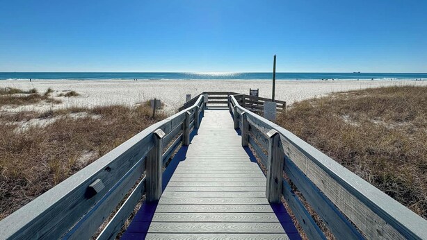A wooden boardwalk leading to a beach with clear skies. - Stylish Beachfront Retreat ~ Gulf Views ~ Pools! (Orange Beach)