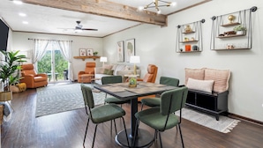 A dining area with a wooden ceiling, a table with chairs, and a sofa. - Stone Creek Retreat 2 BR Home! (Branson)