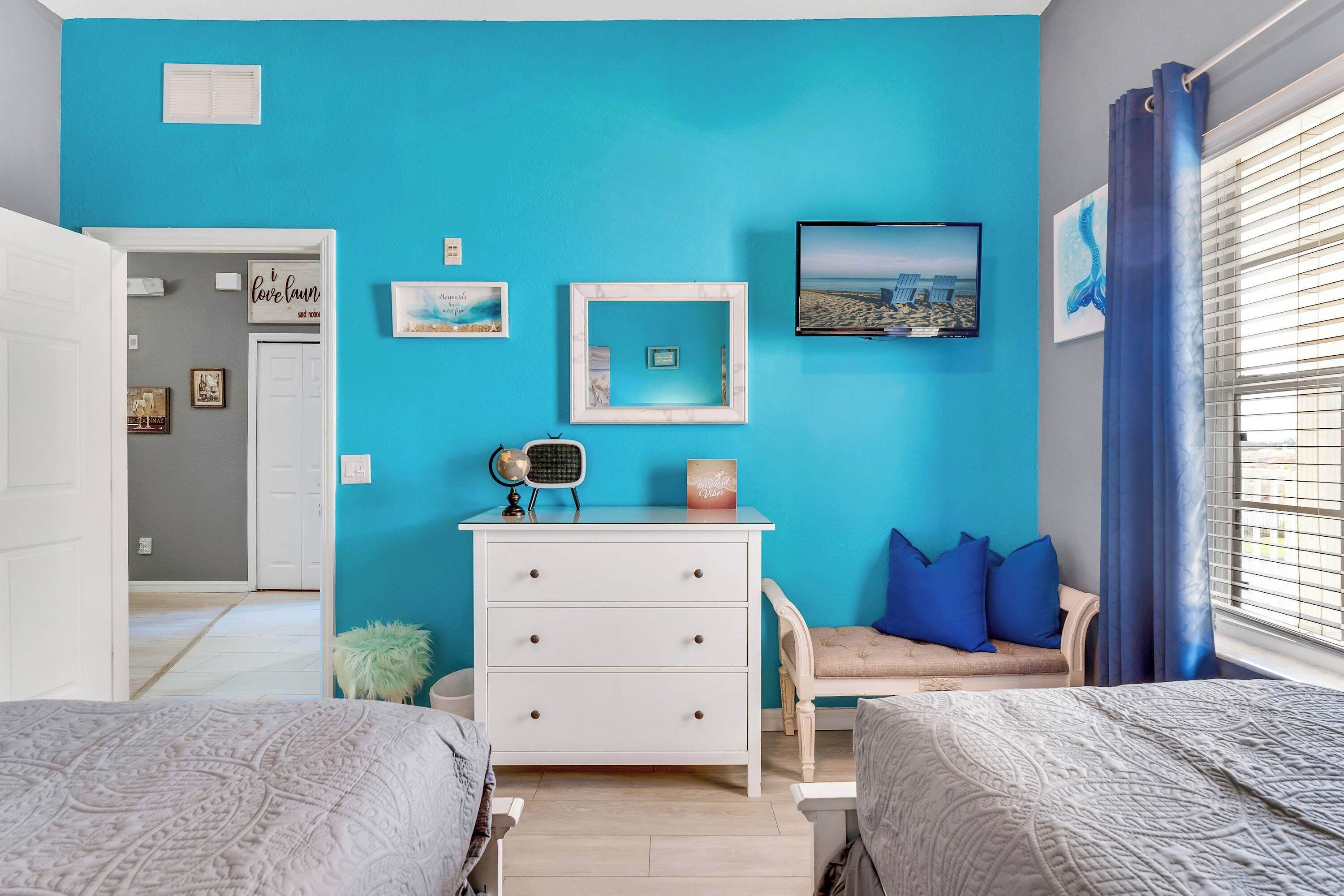 Une chambre avec deux lits, une commode, un globe terrestre et divers éléments de décoration murale.