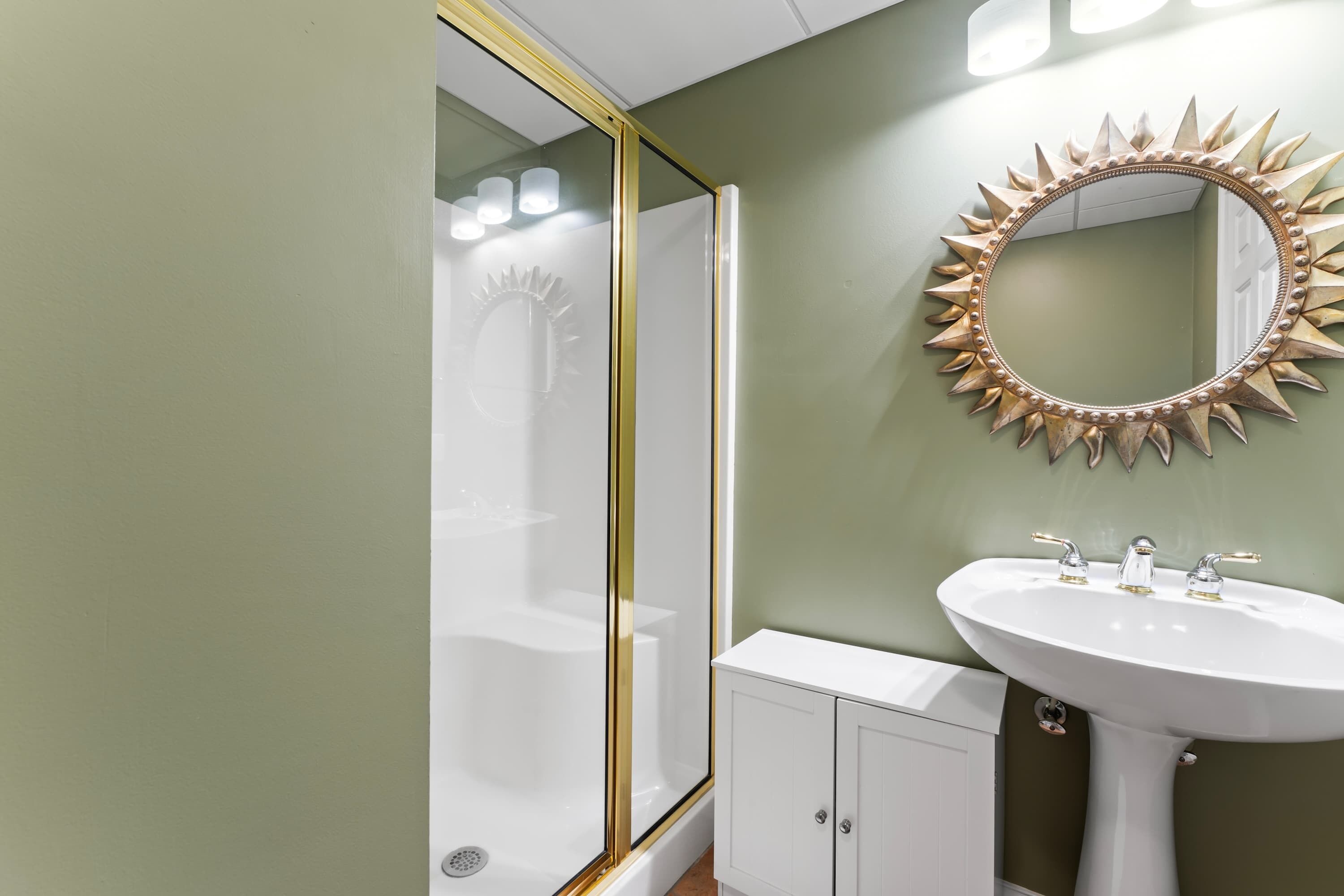 Une salle de bain équipée d’une douche, d’un lavabo et d’un meuble-vasque.