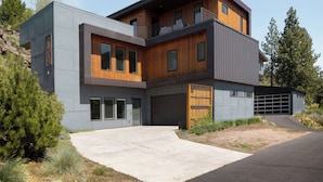 A modern two-story house with a garage, large windows, and a mix of wood and metal exterior materials. - 20 Min to Mt Bachelor! Perfect Basecamp for Skiers (Bend)