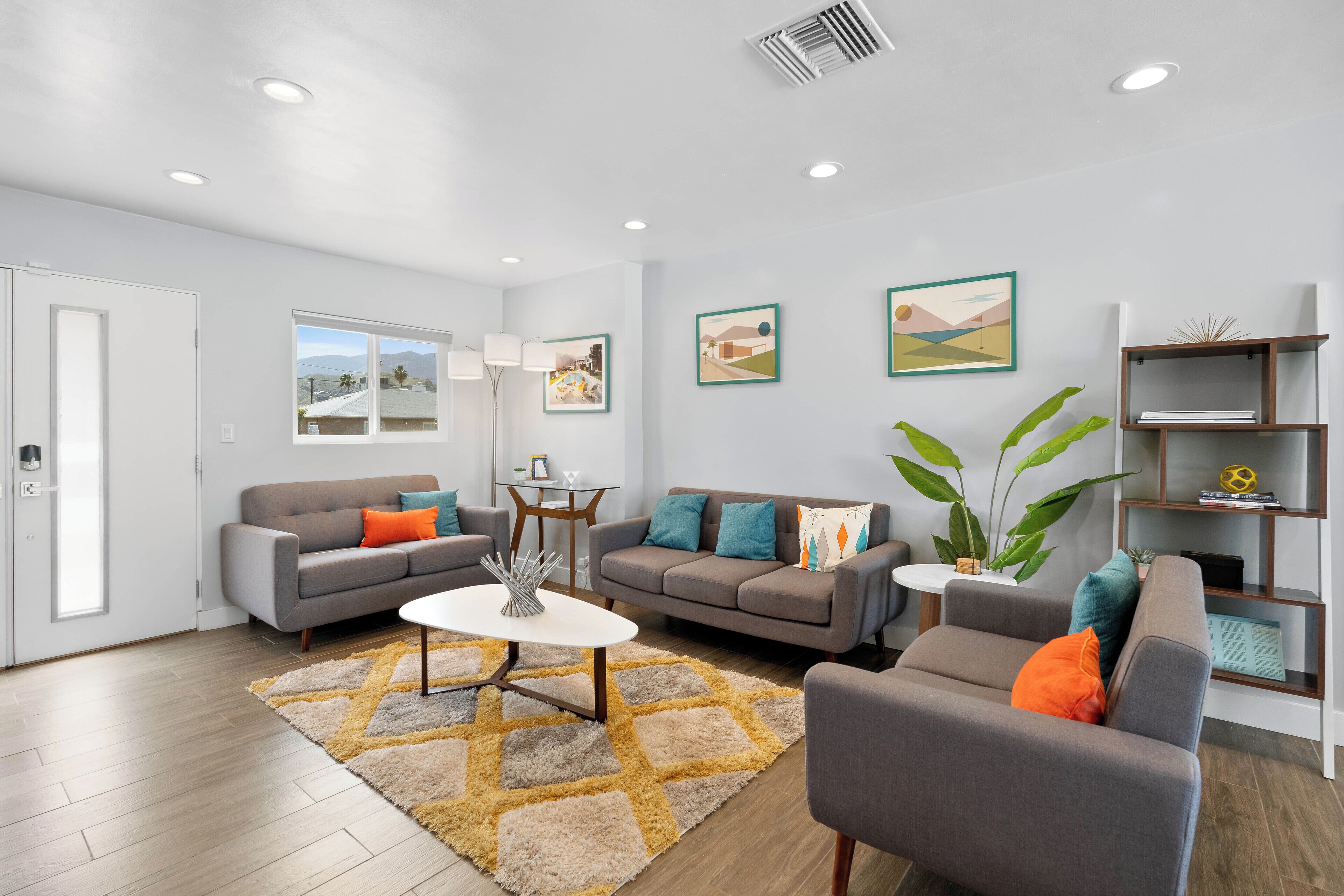 A modern living room with two sofas, a coffee table, and a bookshelf.