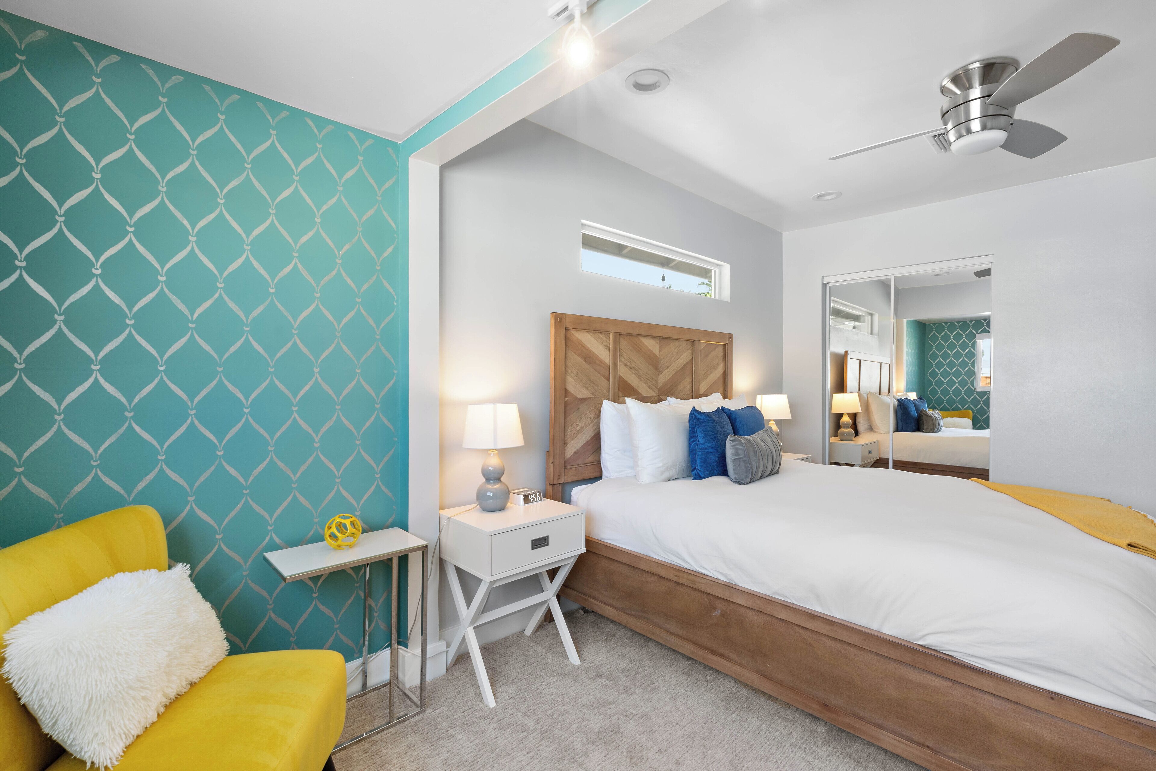A modern bedroom with a bed, nightstand, and chair.