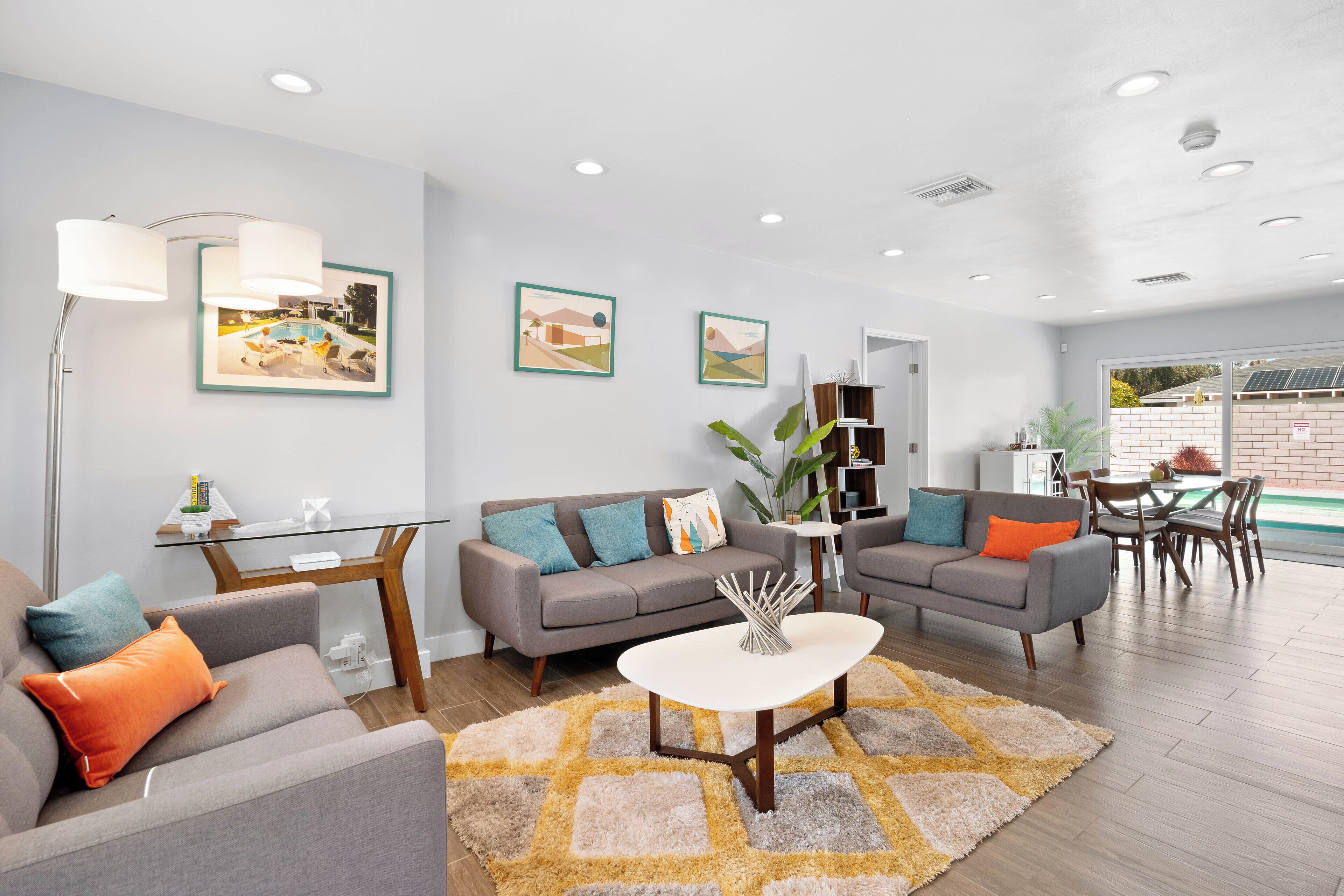 A modern living room with two sofas, a coffee table, and a dining area with chairs and a table.