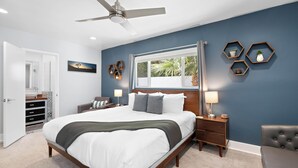 A bedroom with a large bed, a ceiling fan, a window, and hexagonal wall decorations. - The Zen Space Private Pool! (Palm Springs)