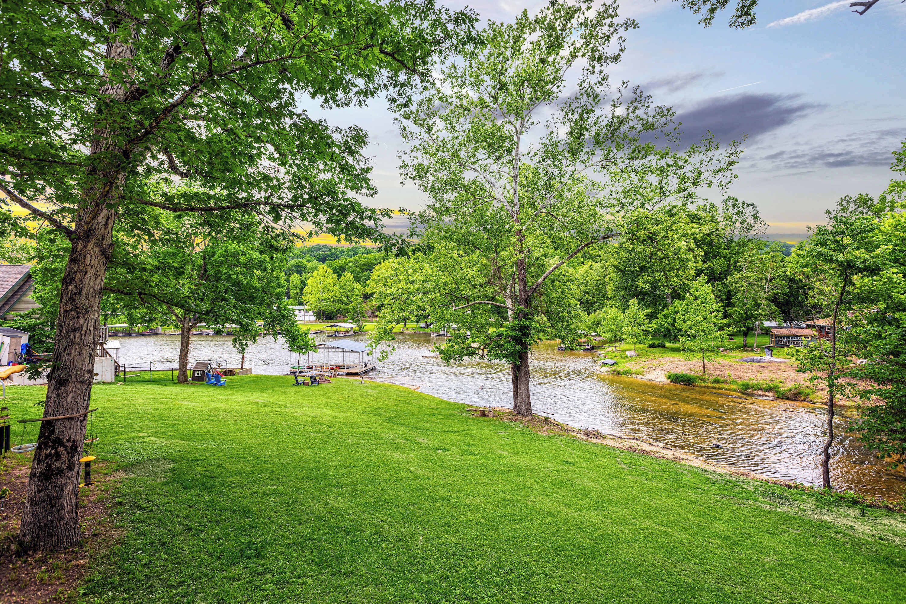 A river with a bridge, surrounded by lush green trees and a grassy area.