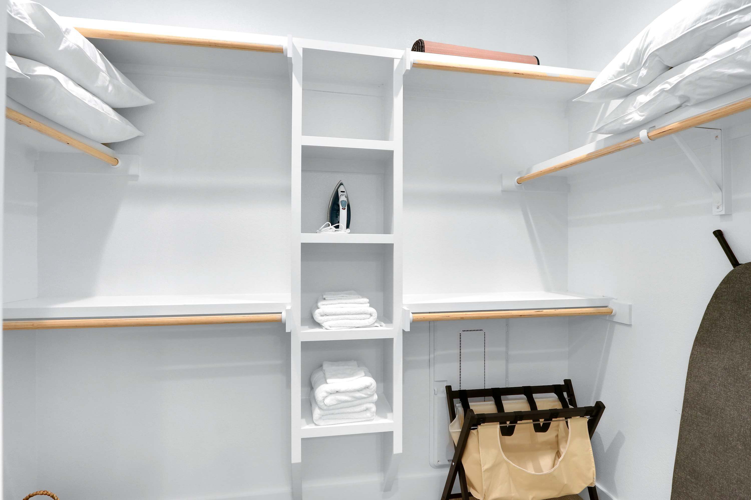 Un armario ordenado con estantes, espacio para colgar ropa y un zapatero.