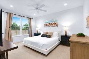 Relax in this serene bedroom with a large bed, nightstands, and a ceiling fan.