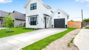 Une maison moderne à deux étages, dotée d’un garage, d’une allée et d’une pelouse bien entretenue.
