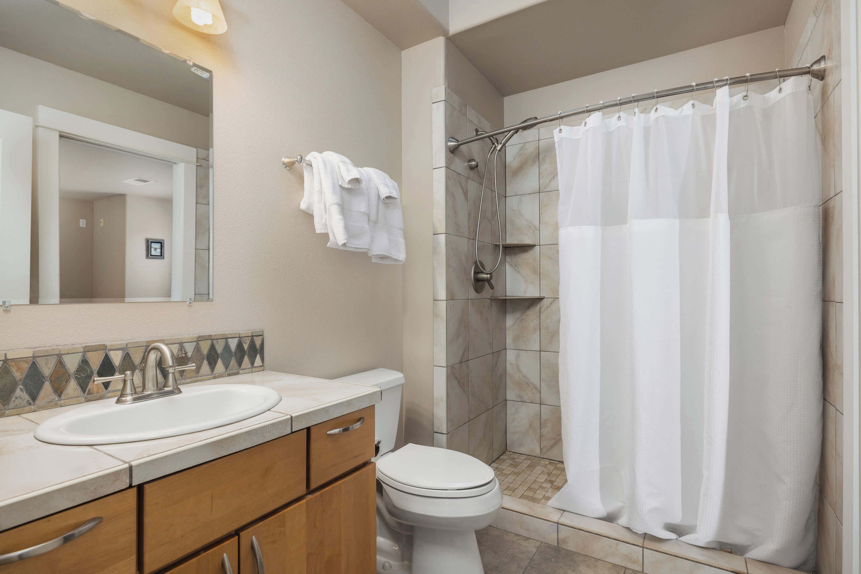 Une salle de bain avec un lavabo, des toilettes et une douche.