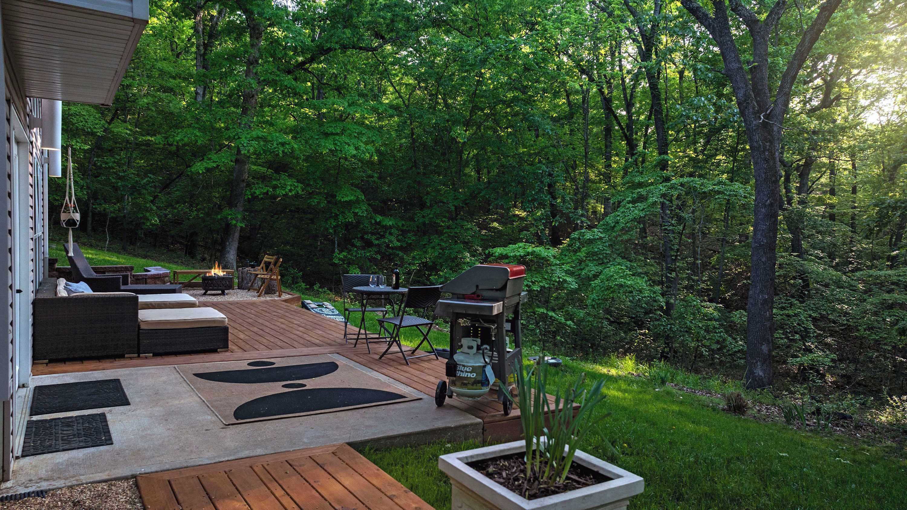 An outdoor deck with seating, a grill, and a fire pit.