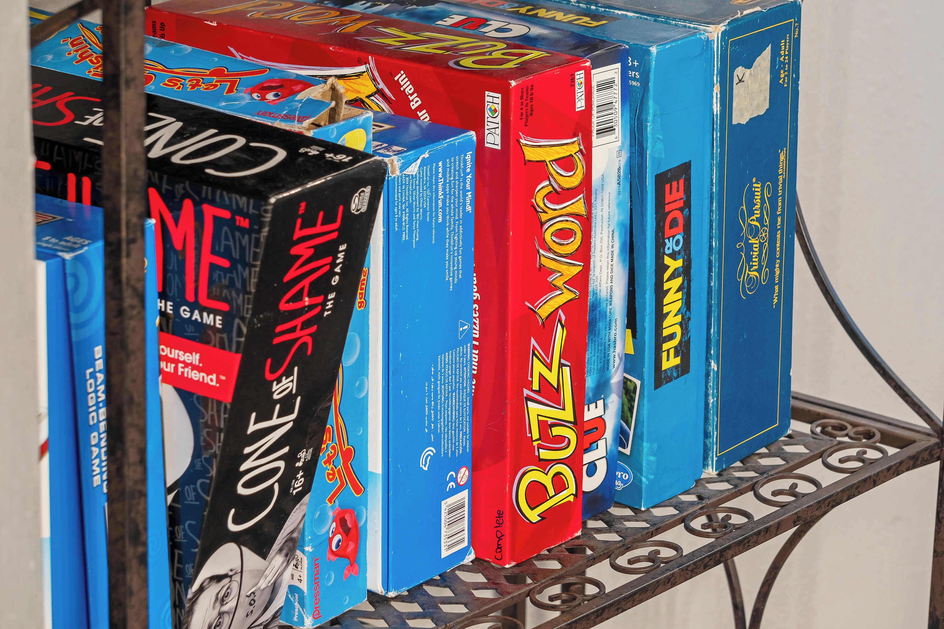 A metal shelf with various board game boxes.
