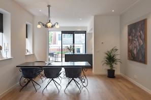 Enjoy meals with family and friends in this stylish dining area, featuring a long table and comfortable seating for four.