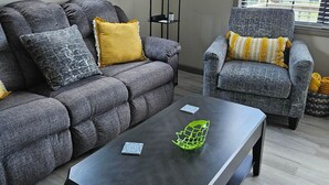 A living room with a sofa, armchair, and a coffee table. - Mountain Views - LMU 1 1/2 (Harrogate)