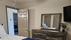 A bedroom with a bed, dresser, mirror, ceiling fan, and a TV. - Mountain Views - LMU 1 1/2 (Harrogate)