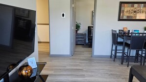 A modern living room with a flat-screen TV, a coffee table, and a dining area with chairs and a table. - Mountain Views - LMU 1 1/2 (Harrogate)