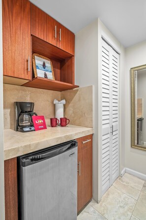 A compact kitchen with a coffee maker, two mugs, and a red bag on the counter. - Ground Floor Studio 4101 at Hanalei Bay Resort, Ocean View, Pool, Tennis (Princeville)