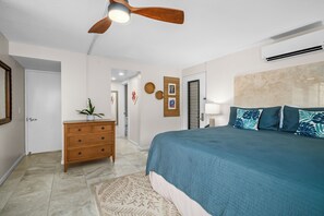 A bedroom with a bed, dresser, ceiling fan, and a door leading to a bathroom. - Ground Floor Studio 4101 at Hanalei Bay Resort, Ocean View, Pool, Tennis (Princeville)
